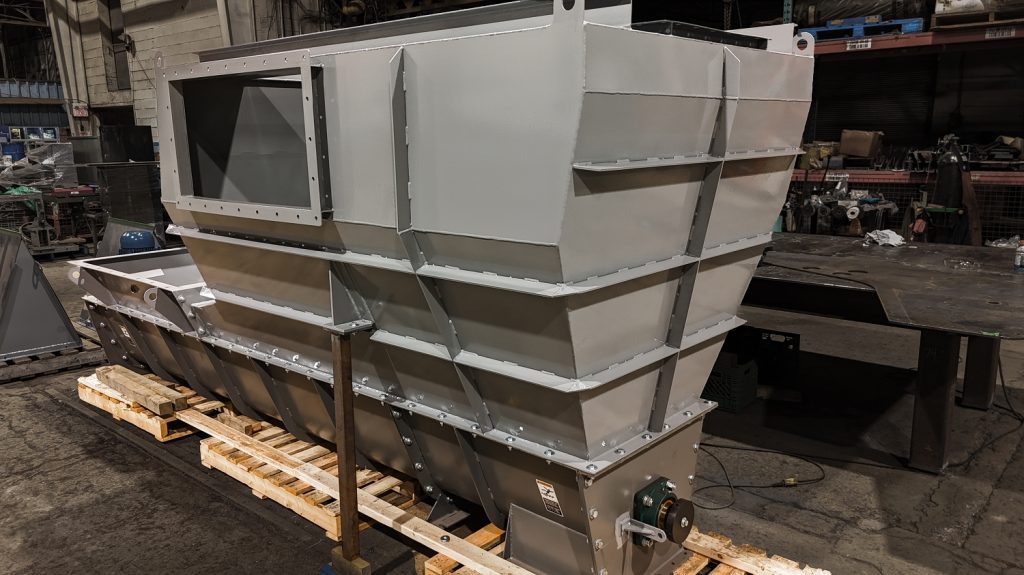 Discharge end of a grey custom screw conveyor feeder for bulk materials