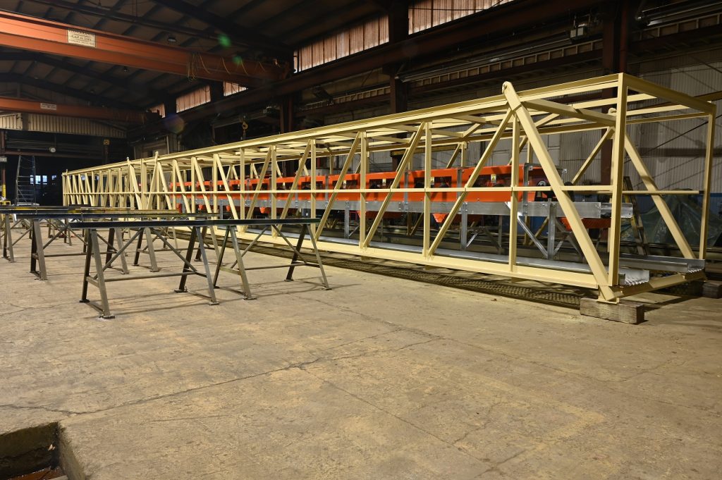 Gallery conveyor structure under construction with truss frame and walkway supports