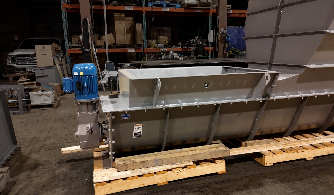 Drive end of a custom screw conveyor showing motor and gearbox assembly